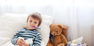 A Parents’ Guide to Surviving Cold and Flu Season Sick child boy lying in bed with a fever, resting at home
