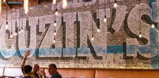 Cuzin’s Seafood Clam Bar Cuzin's logo on Wall